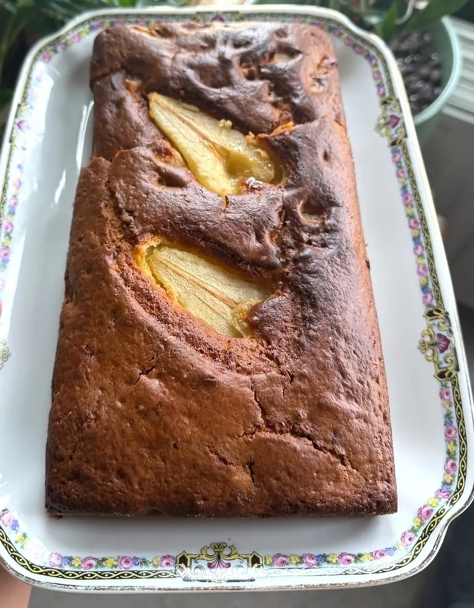 Cake aux poires doré, deux demi-poires fondues affleurant la croûte