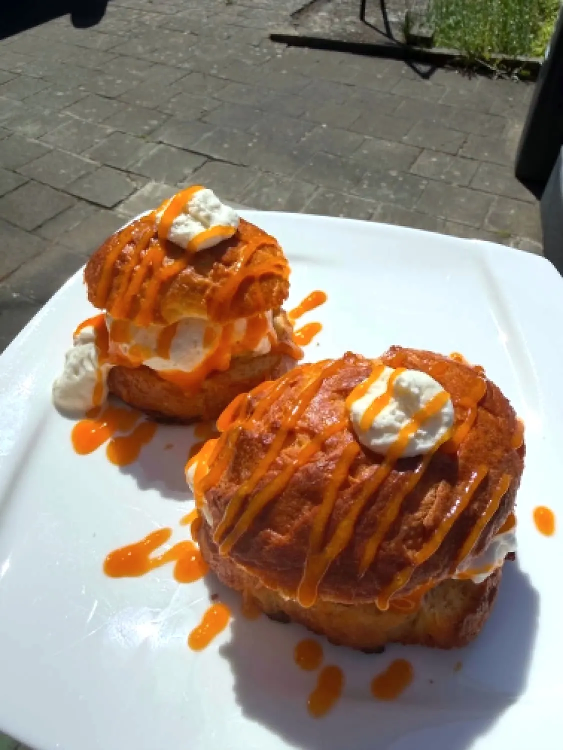 Deux choux garnis de chantilly, nappés d'un coulis d'abricot