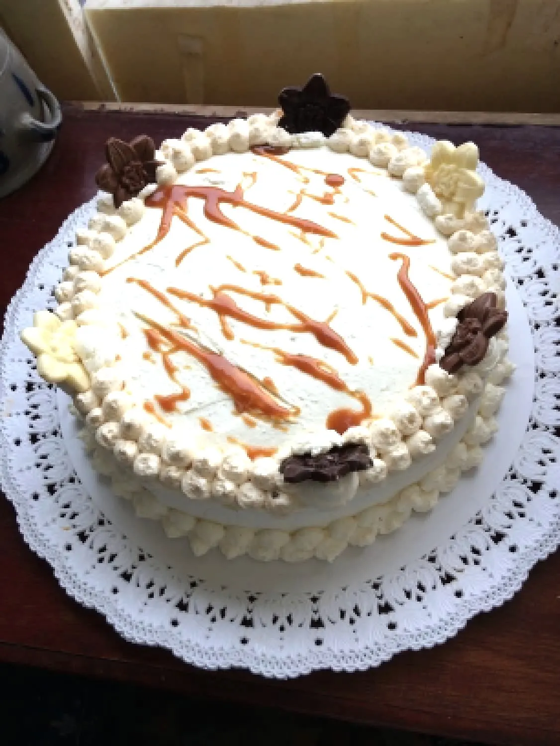 Gâteau rond à la chantilly nappé de filets de caramel sur napperon