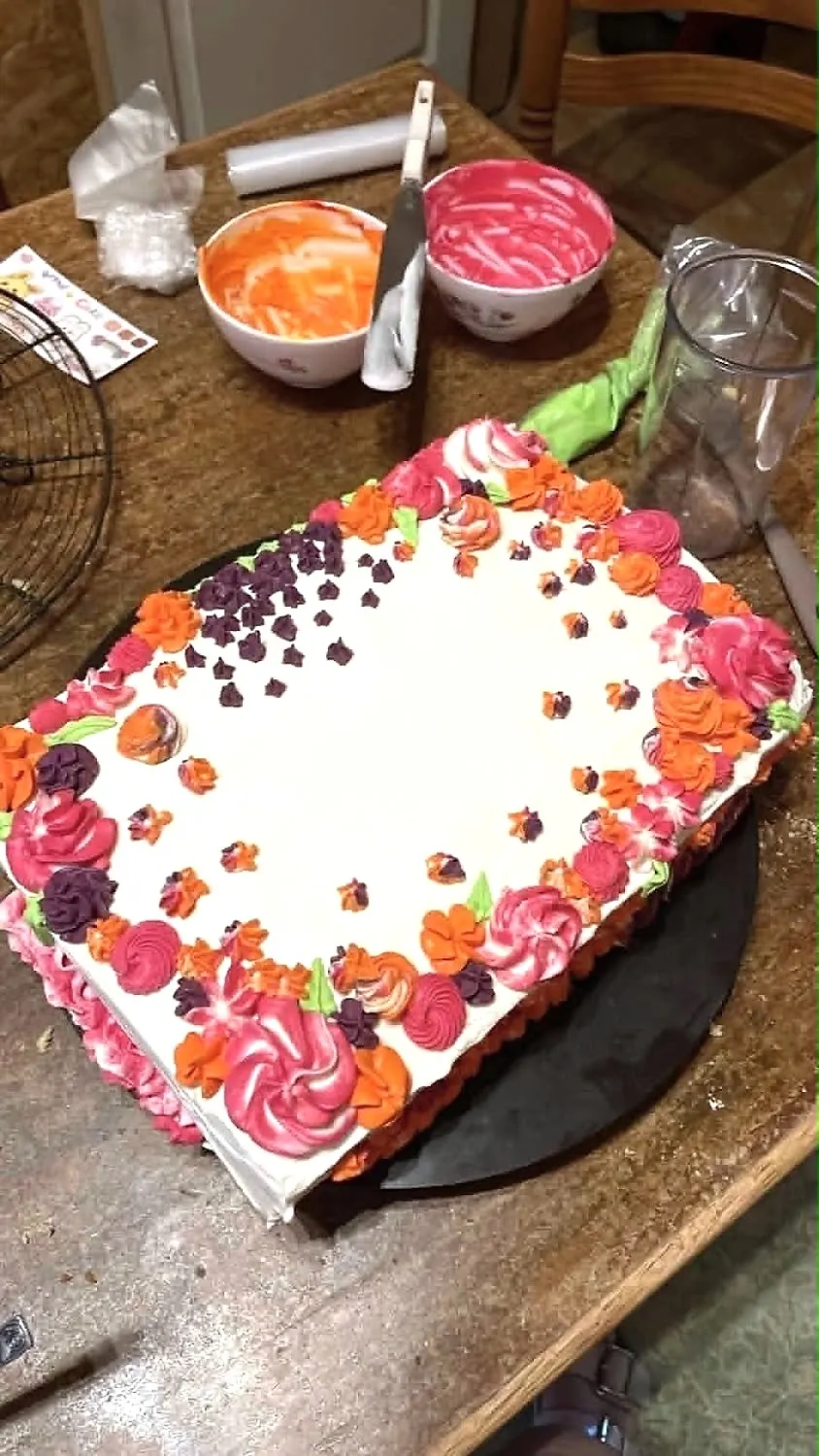 Gâteau rectangulaire couvert de fleurs en crème au beurre colorées