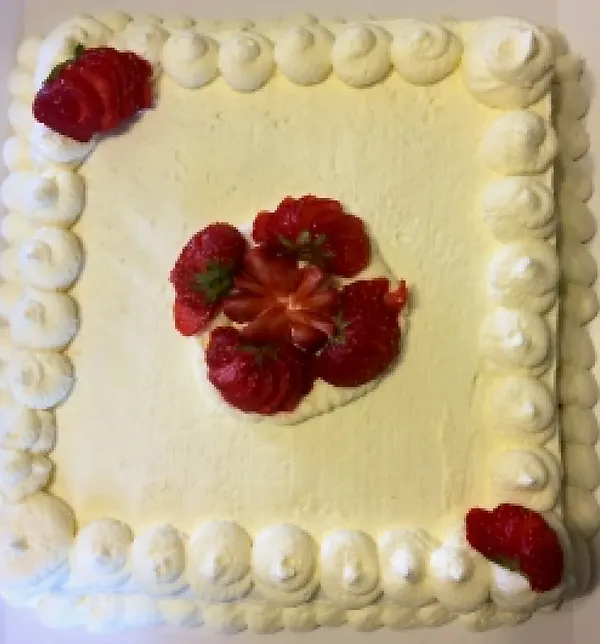 Gâteau carré à la crème vanille surmonté de fraises fraîches