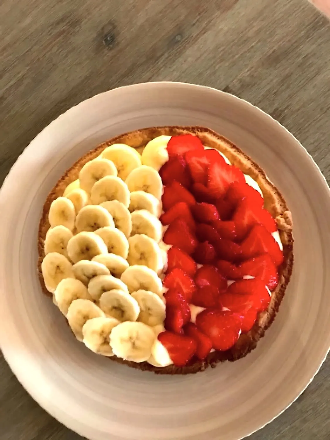 Tarte partagée en deux, moitié bananes moitié fraises