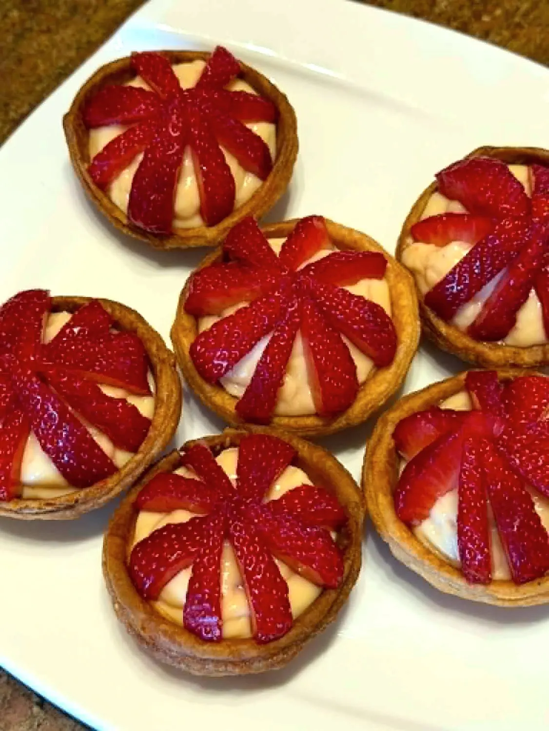 Tartelettes aux fraises disposées en éventail sur crème pâtissière