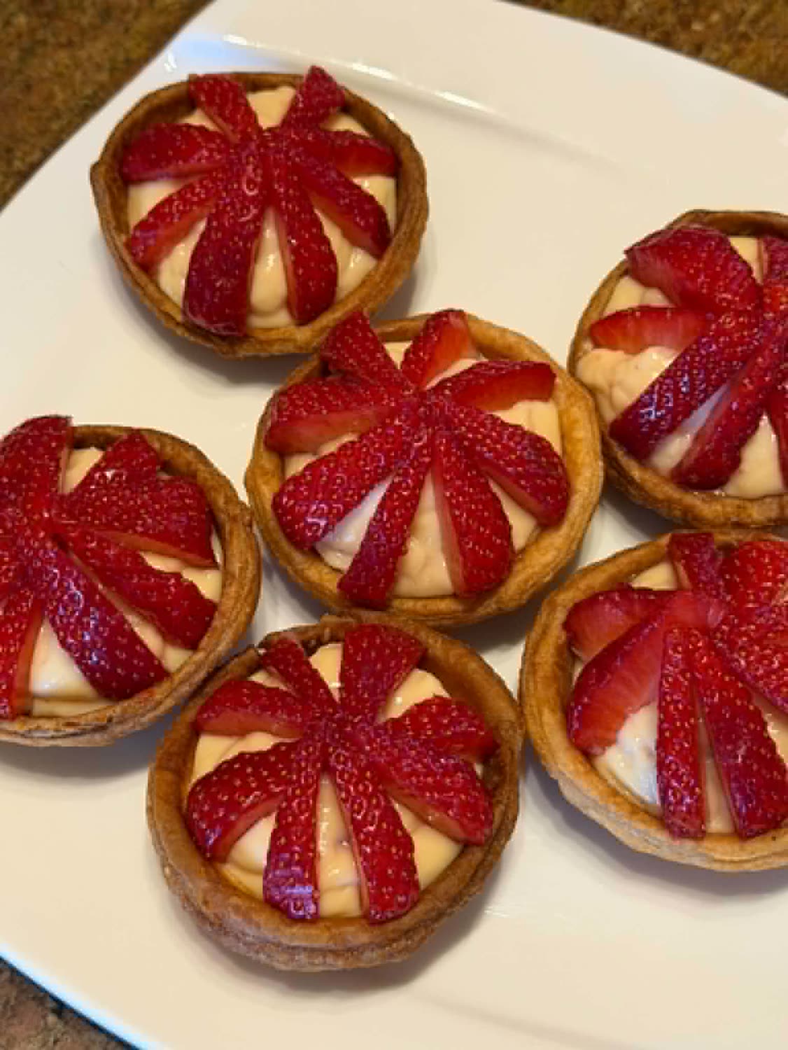 Tartelettes aux fraises disposées en éventail sur crème pâtissière